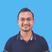 Utsav, smiling in glasses, in front of a plain blue background